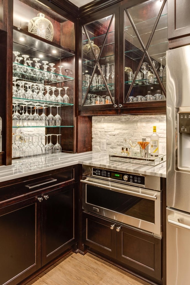 ワシントンD.C.にある小さなトラディショナルスタイルのおしゃれなホームバー (L型、濃色木目調キャビネット、白いキッチンパネル、石タイルのキッチンパネル) の写真