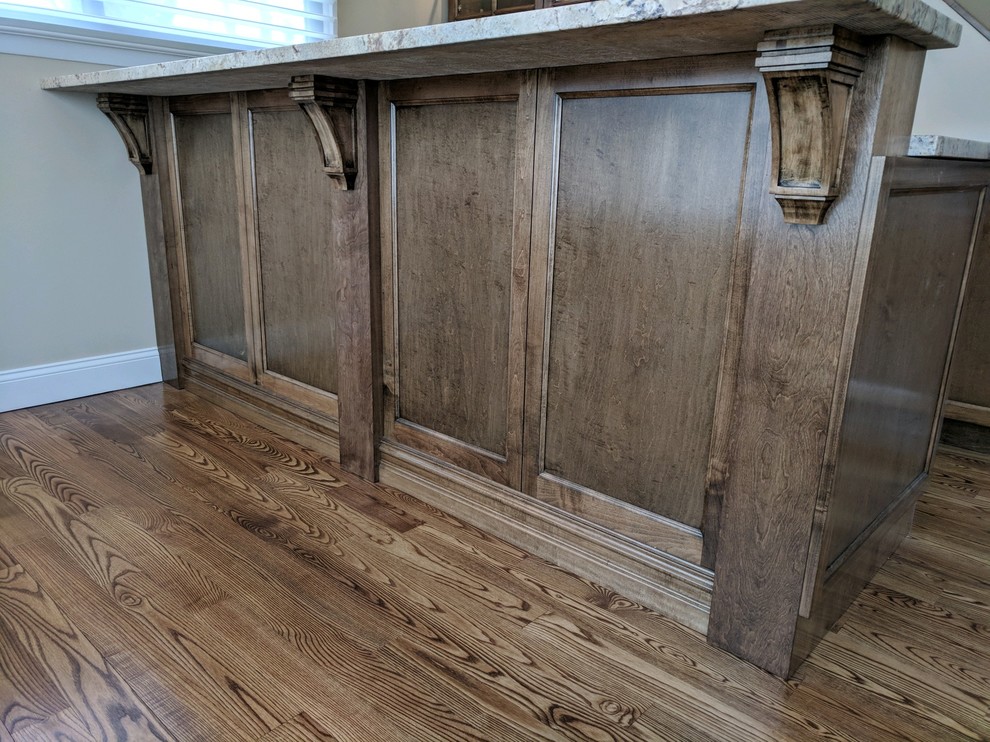 Diseño de bar en casa tradicional con armarios estilo shaker, puertas de armario de madera en tonos medios, encimera de granito, suelo de madera oscura y suelo marrón