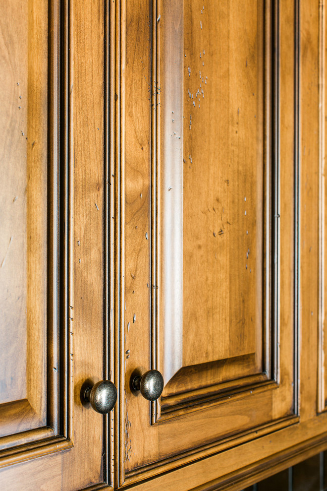 Réalisation d'un bar de salon avec évier tradition en bois brun de taille moyenne avec un placard avec porte à panneau surélevé, un plan de travail en verre, une crédence miroir et sol en béton ciré.