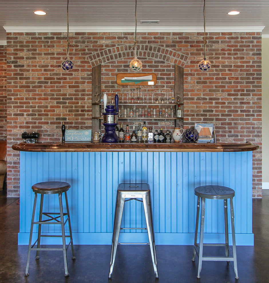 Cette image montre un bar de salon rustique avec des tabourets et des portes de placard bleues.