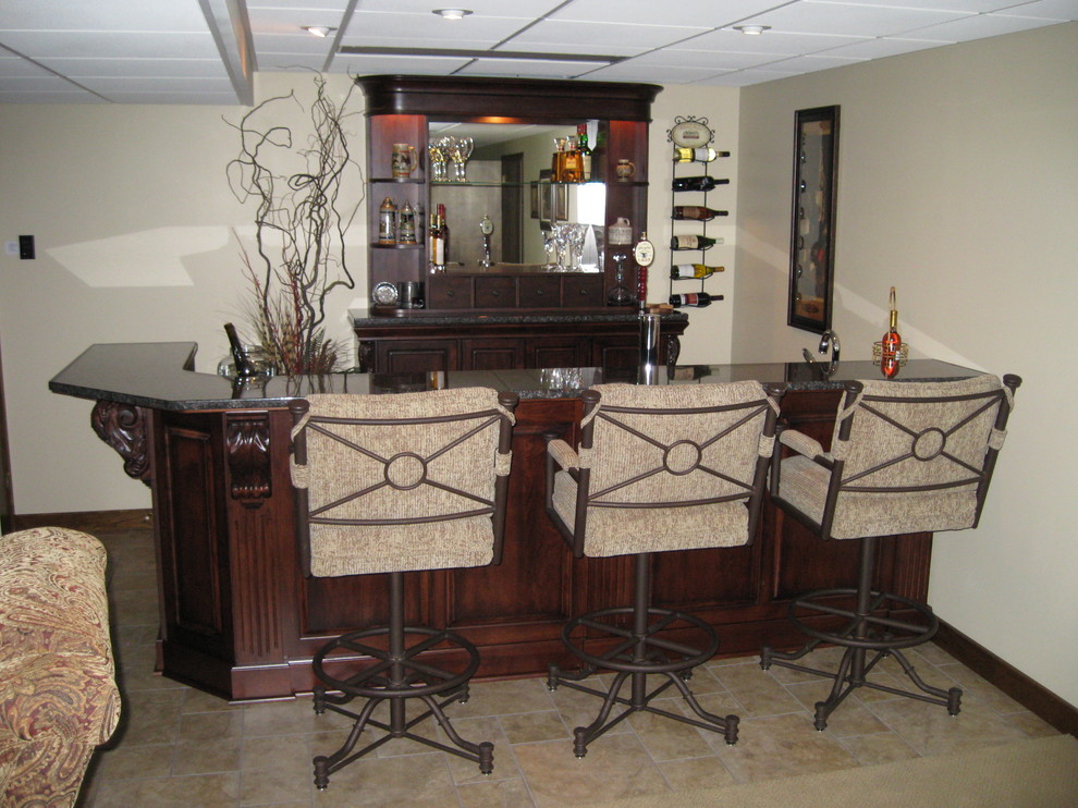 This is an example of a medium sized classic home bar in Other.
