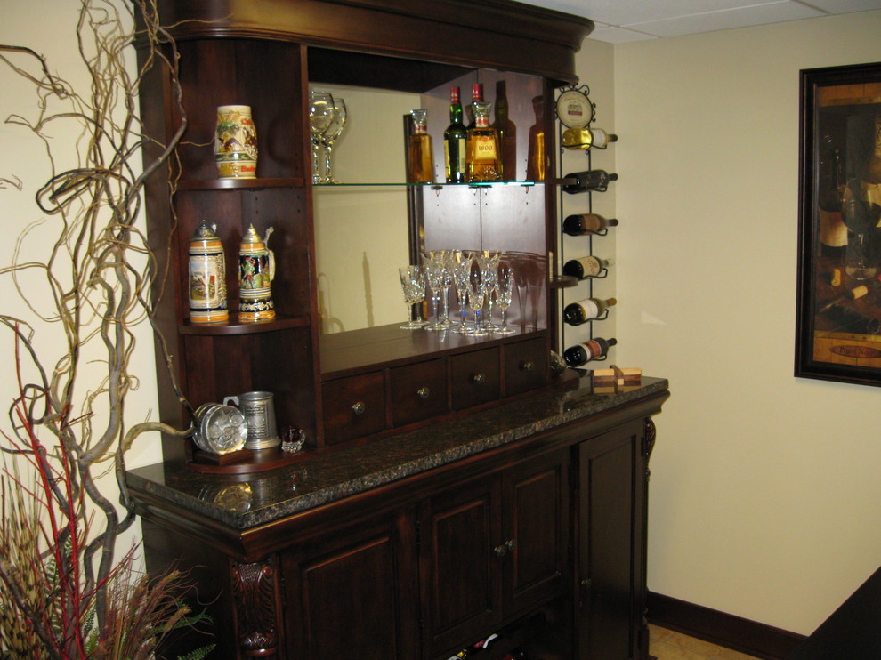 This is an example of a medium sized traditional home bar in Other.