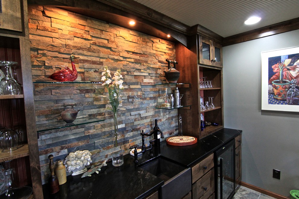 Diseño de bar en casa con barra de bar clásico renovado de tamaño medio con fregadero bajoencimera, armarios estilo shaker, puertas de armario de madera en tonos medios, salpicadero multicolor, salpicadero de pizarra, suelo de pizarra y suelo marrón