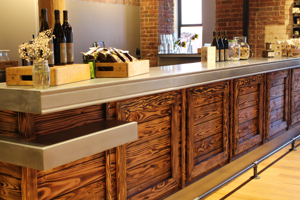 Foto di un ampio angolo bar con lavandino bohémian con ante in legno bruno, top in zinco e parquet chiaro