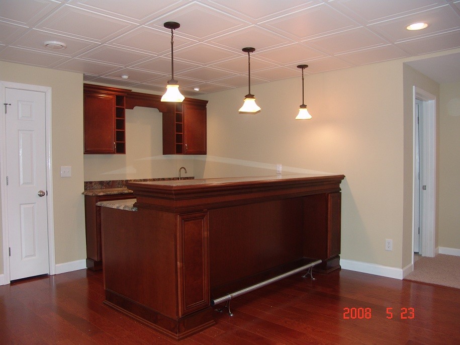 Large traditional single-wall breakfast bar in St Louis with a submerged sink, recessed-panel cabinets, dark wood cabinets, granite worktops and dark hardwood flooring.