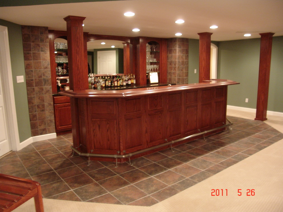 Esempio di un grande bancone bar tradizionale con lavello sottopiano, ante in legno bruno, top in granito, pavimento con piastrelle in ceramica e ante con bugna sagomata