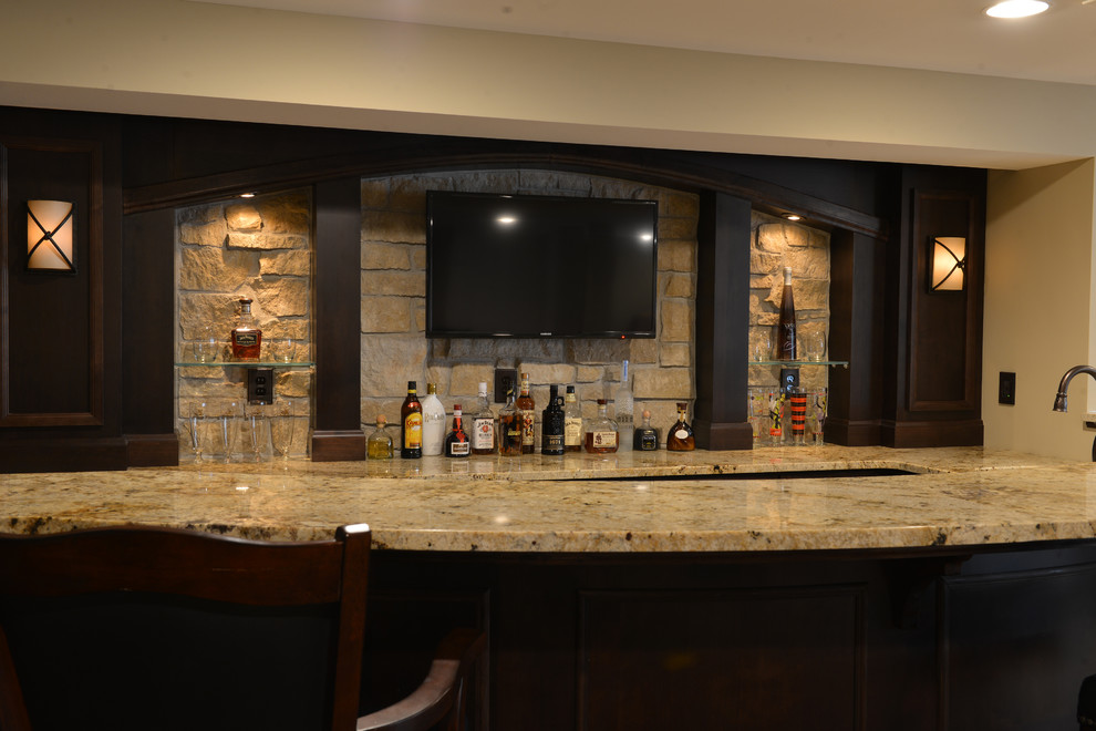 Cette image montre un bar de salon avec évier parallèle chalet en bois foncé de taille moyenne avec un plan de travail en granite, une crédence grise, une crédence en carrelage de pierre, parquet foncé, un sol marron et un plan de travail marron.