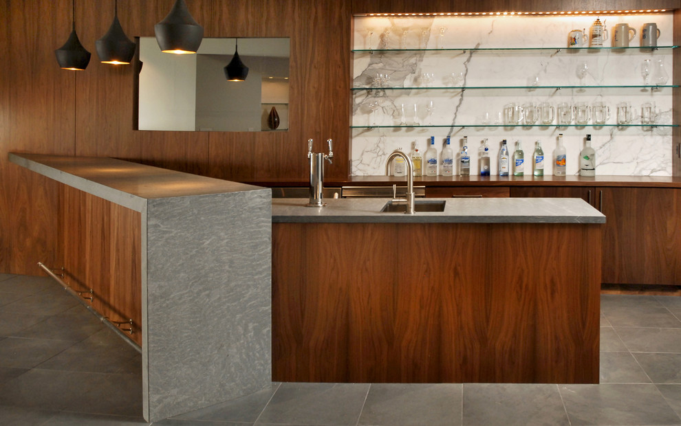 Medium sized contemporary u-shaped wet bar in Denver with a submerged sink, flat-panel cabinets, dark wood cabinets, white splashback and stone slab splashback.
