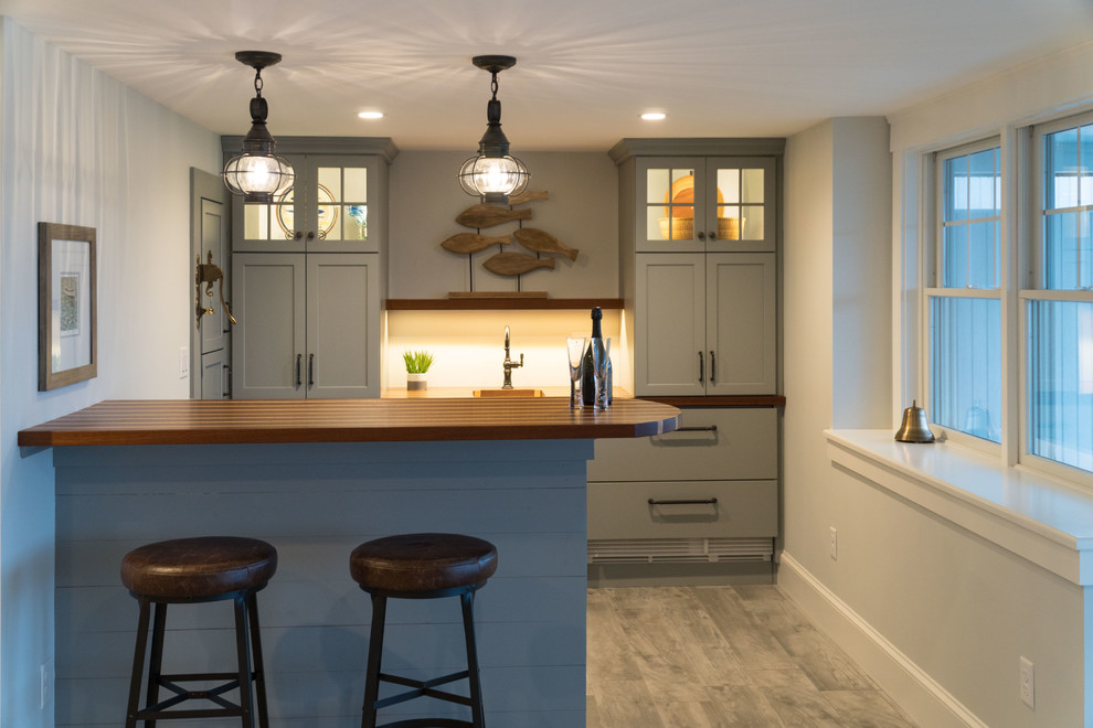 This is an example of a medium sized nautical galley breakfast bar in Boston with a submerged sink, shaker cabinets, blue cabinets, wood worktops, porcelain flooring and grey floors.