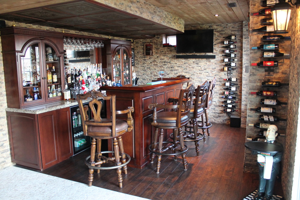 Immagine di un grande bancone bar mediterraneo con lavello da incasso, ante marroni, top in granito, parquet scuro, pavimento marrone e paraspruzzi a specchio