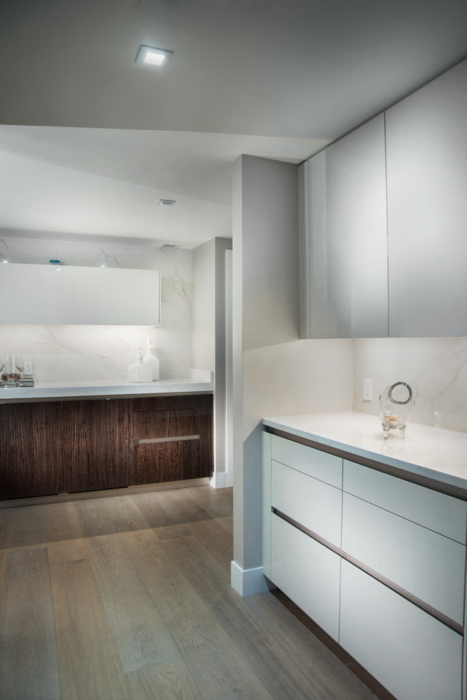 Example of a mid-sized minimalist single-wall light wood floor and beige floor wet bar design in Miami with an undermount sink, flat-panel cabinets, white cabinets, white backsplash and white countertops