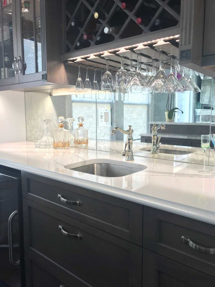 This is an example of a medium sized beach style galley wet bar in Philadelphia with a submerged sink, shaker cabinets, grey cabinets, engineered stone countertops, mirror splashback and white worktops.