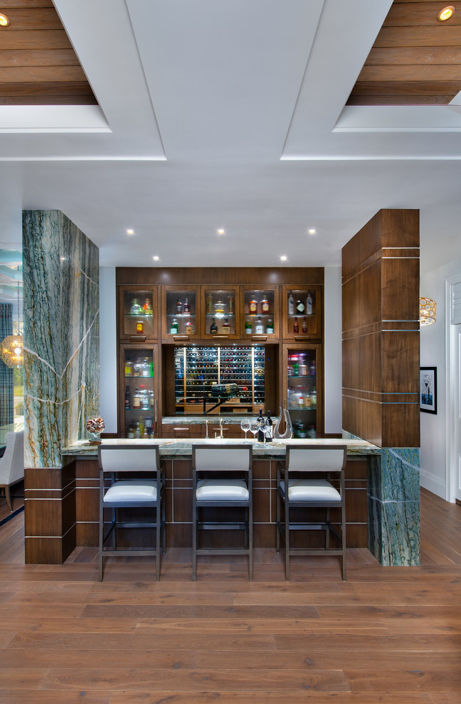 Beach style medium tone wood floor seated home bar photo in Miami with glass-front cabinets and dark wood cabinets