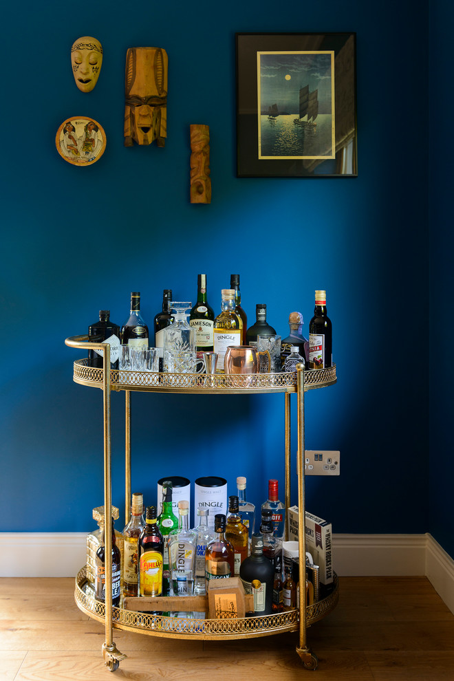 Foto de bar en casa con carrito de bar ecléctico con suelo de madera en tonos medios y suelo marrón