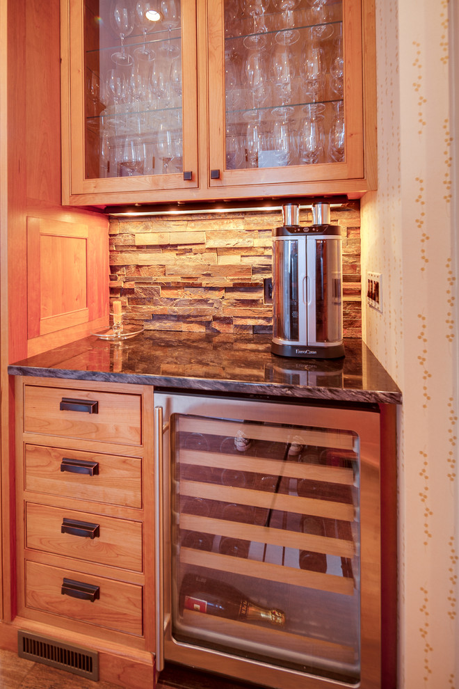 ワシントンD.C.にある小さなトラディショナルスタイルのおしゃれなホームバー (I型、ガラス扉のキャビネット、中間色木目調キャビネット、御影石カウンター、茶色いキッチンパネル、ボーダータイルのキッチンパネル) の写真
