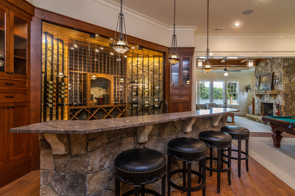 Inspiration for a rustic galley dark wood floor and brown floor seated home bar remodel in Charlotte with shaker cabinets, dark wood cabinets and gray countertops