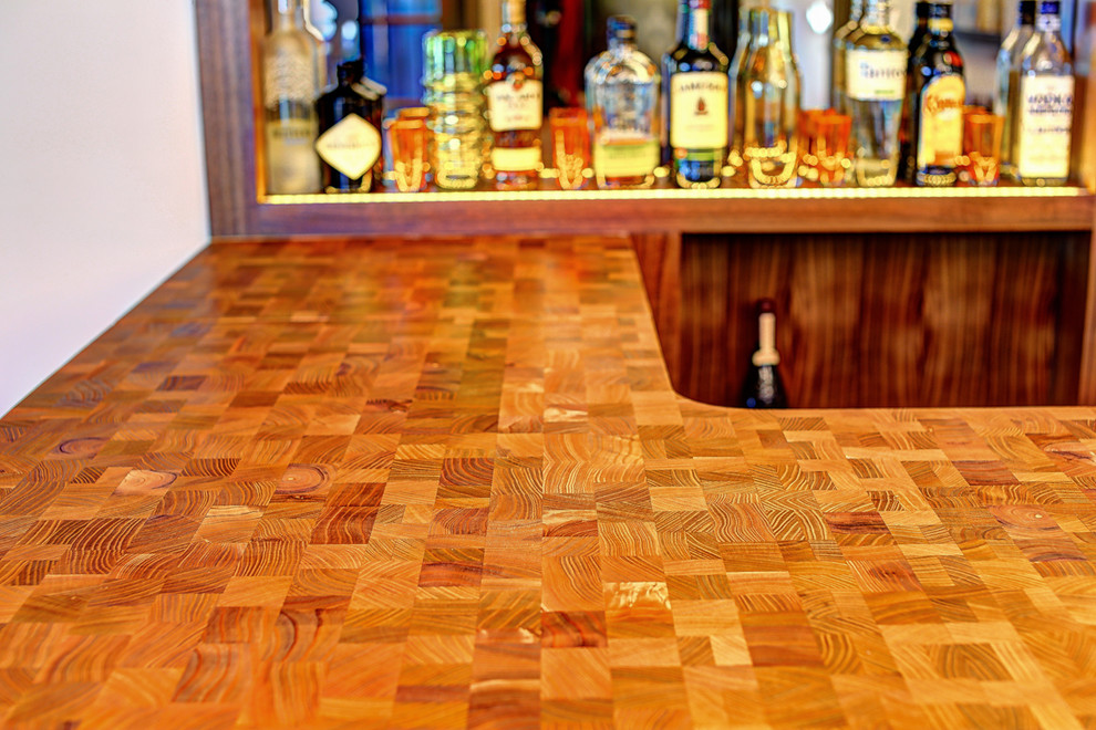Cette image montre un bar de salon avec évier linéaire design en bois brun de taille moyenne avec un placard sans porte, un sol en bois brun, un sol marron et un plan de travail en bois.