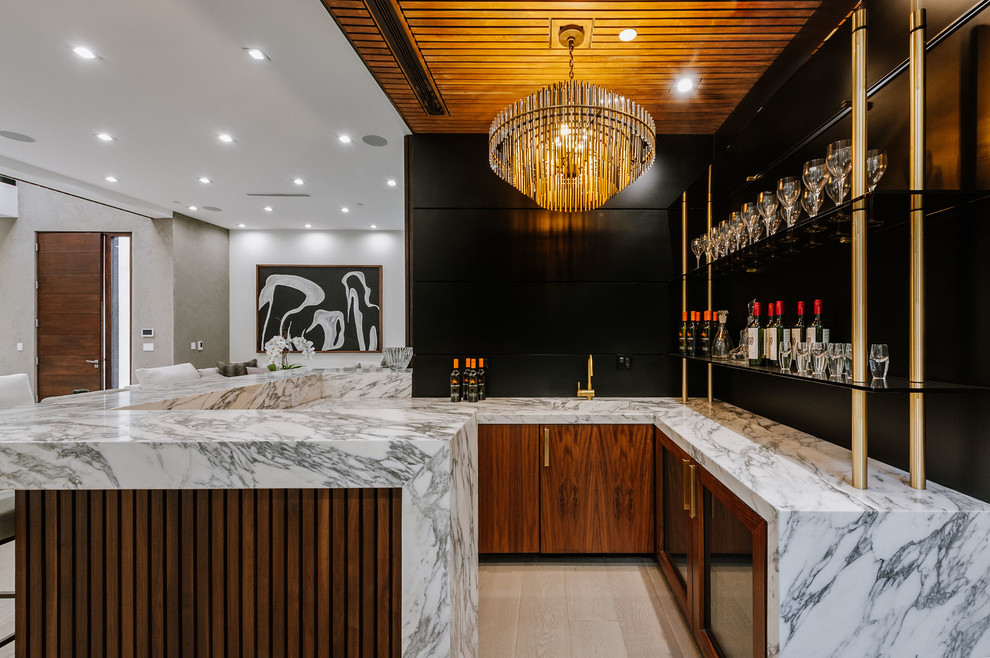 Large contemporary u-shaped breakfast bar in Los Angeles with an integrated sink, flat-panel cabinets, dark wood cabinets, marble worktops and light hardwood flooring.
