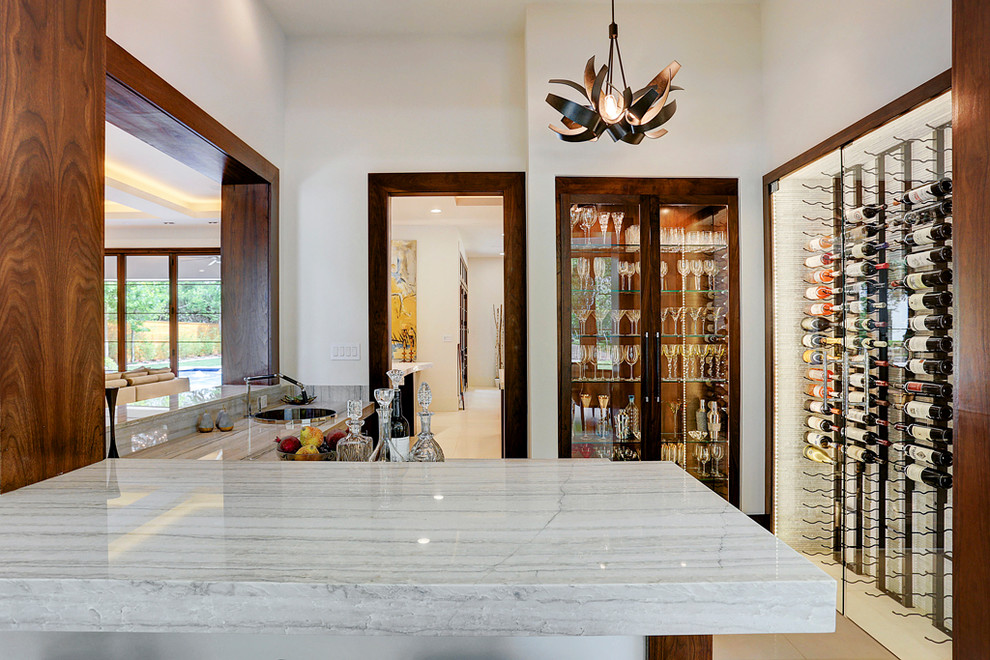 Immagine di un bancone bar minimal di medie dimensioni con lavello da incasso, top in saponaria, paraspruzzi beige, paraspruzzi con piastrelle in pietra, pavimento in marmo e pavimento beige