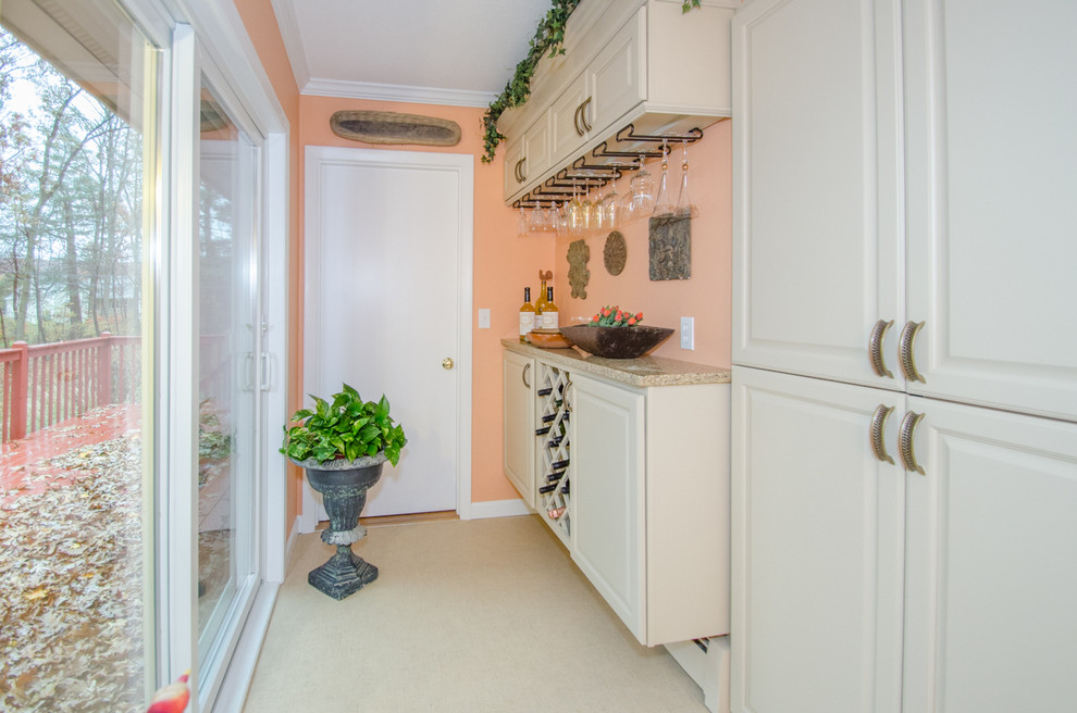 Ejemplo de bar en casa con fregadero lineal tradicional pequeño con armarios con paneles con relieve, puertas de armario beige y suelo beige