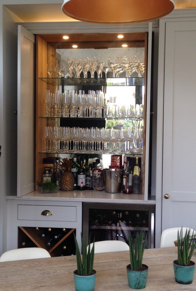 Immagine di un piccolo angolo bar con lavandino vittoriano con ante in stile shaker, ante grigie, top in marmo, paraspruzzi a specchio e top grigio