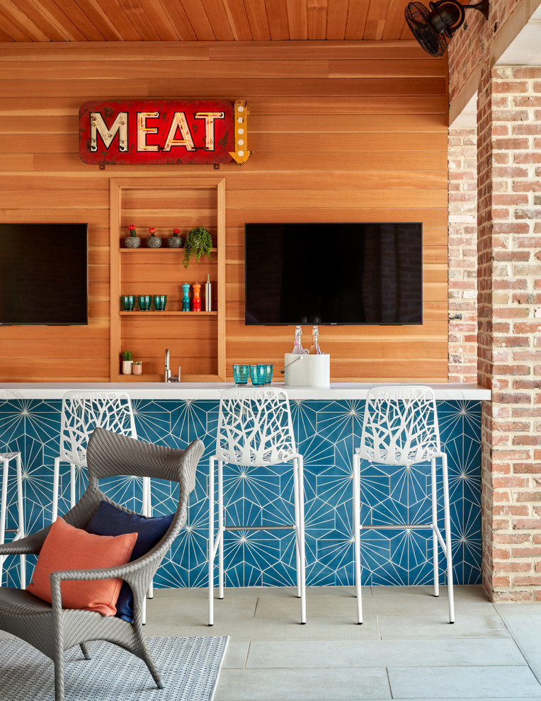 Foto di un bancone bar classico di medie dimensioni con paraspruzzi marrone, paraspruzzi in legno, pavimento grigio, top bianco e pavimento in cemento