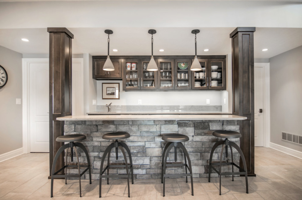 Large elegant single-wall travertine floor seated home bar photo in Kansas City with an undermount sink, glass-front cabinets and dark wood cabinets