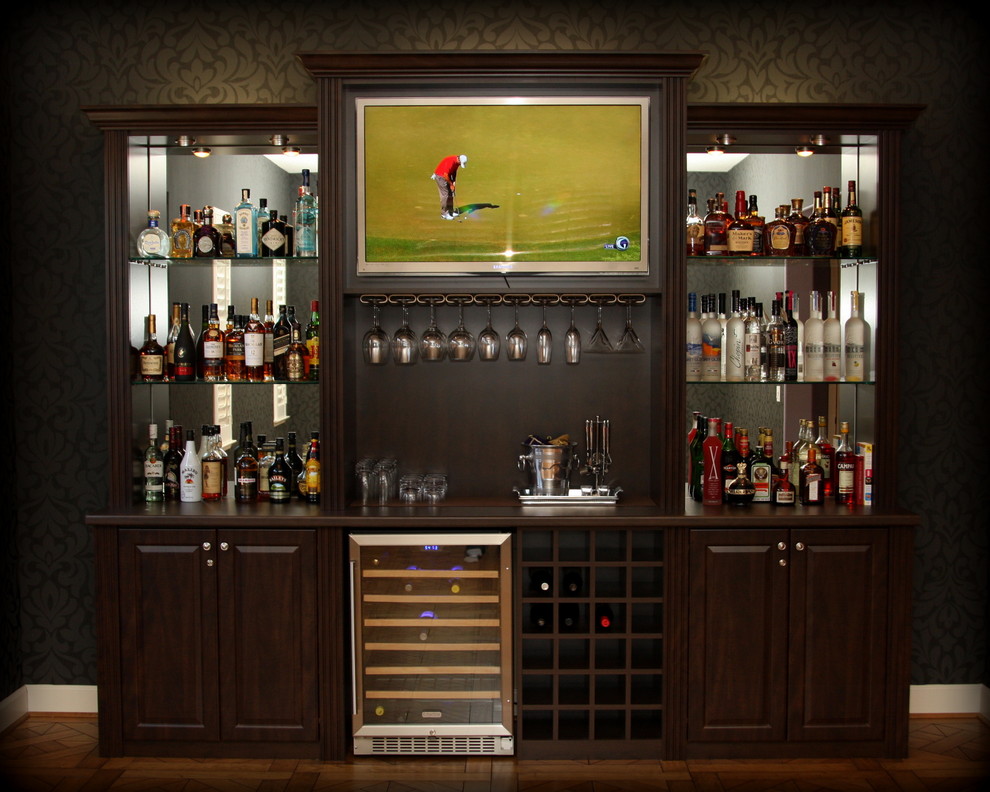 Home bar - mid-sized traditional single-wall medium tone wood floor and brown floor home bar idea in San Francisco with no sink, dark wood cabinets, laminate countertops, raised-panel cabinets and mirror backsplash