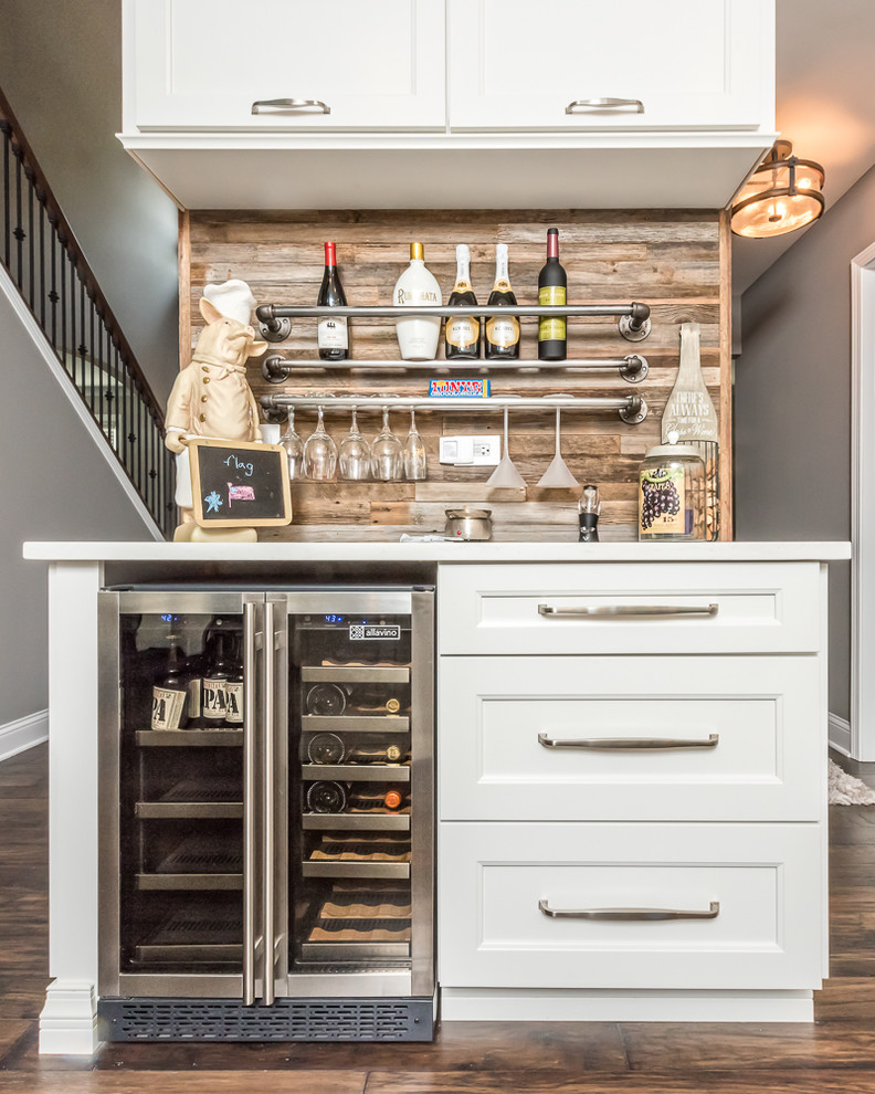 Diseño de bar en casa lineal tradicional pequeño sin pila con puertas de armario blancas, salpicadero marrón, salpicadero de madera, suelo marrón, suelo de madera oscura, encimeras blancas, armarios estilo shaker y encimera de cuarzo compacto