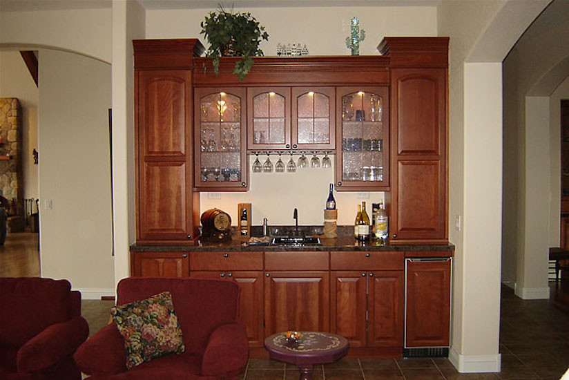 Immagine di un angolo bar con lavandino mediterraneo di medie dimensioni con lavello da incasso, ante con bugna sagomata, ante in legno scuro, top in granito, pavimento in ardesia e pavimento marrone