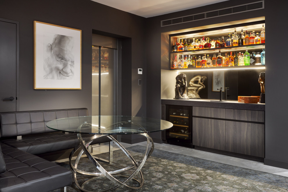 Medium sized contemporary home bar in Perth with an integrated sink, flat-panel cabinets, dark wood cabinets, tile countertops, mirror splashback, concrete flooring, grey floors and black worktops.