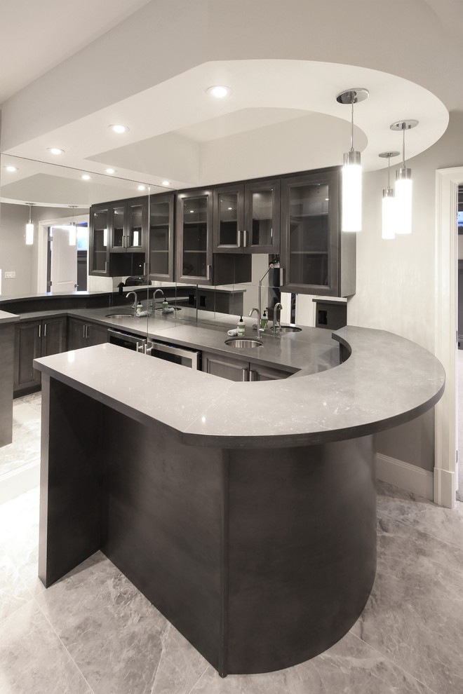 Inspiration for an expansive contemporary u-shaped breakfast bar in Vancouver with a submerged sink, glass-front cabinets, grey cabinets, engineered stone countertops, white splashback, mirror splashback and grey floors.