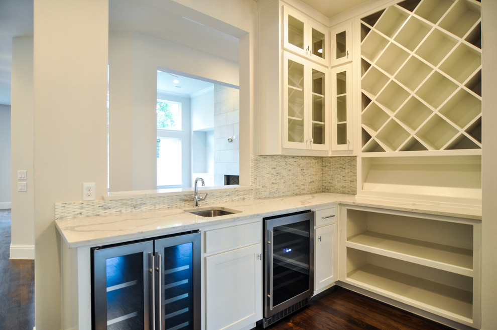 Mid-sized transitional l-shaped dark wood floor wet bar photo in Dallas with an undermount sink, shaker cabinets, white cabinets, quartzite countertops, white backsplash and stone tile backsplash