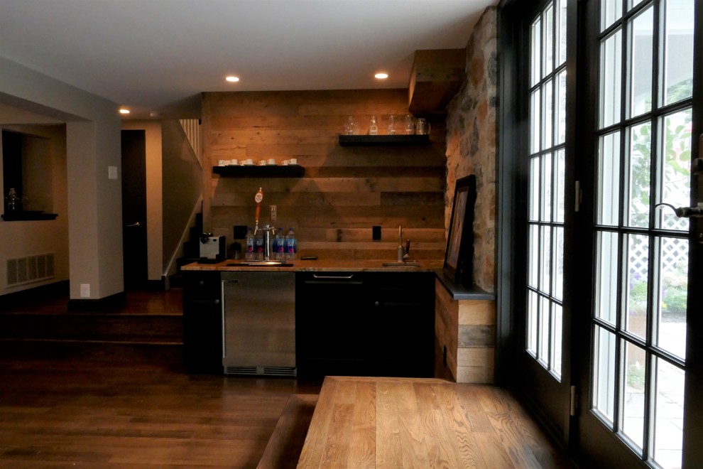This is an example of a medium sized rural single-wall home bar in Philadelphia with a submerged sink, dark wood cabinets, granite worktops, brown splashback, wood splashback, medium hardwood flooring and brown floors.