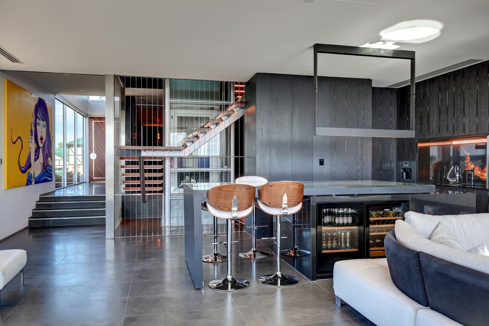 アデレードにあるコンテンポラリースタイルのおしゃれなウェット バー (フラットパネル扉のキャビネット、黒いキャビネット、グレーの床、グレーのキッチンカウンター) の写真