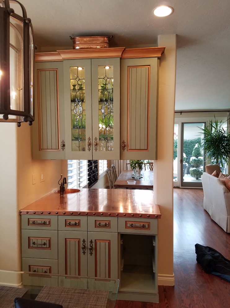 Medium sized country single-wall wet bar in Denver with an integrated sink, raised-panel cabinets, green cabinets, copper worktops, medium hardwood flooring and brown floors.