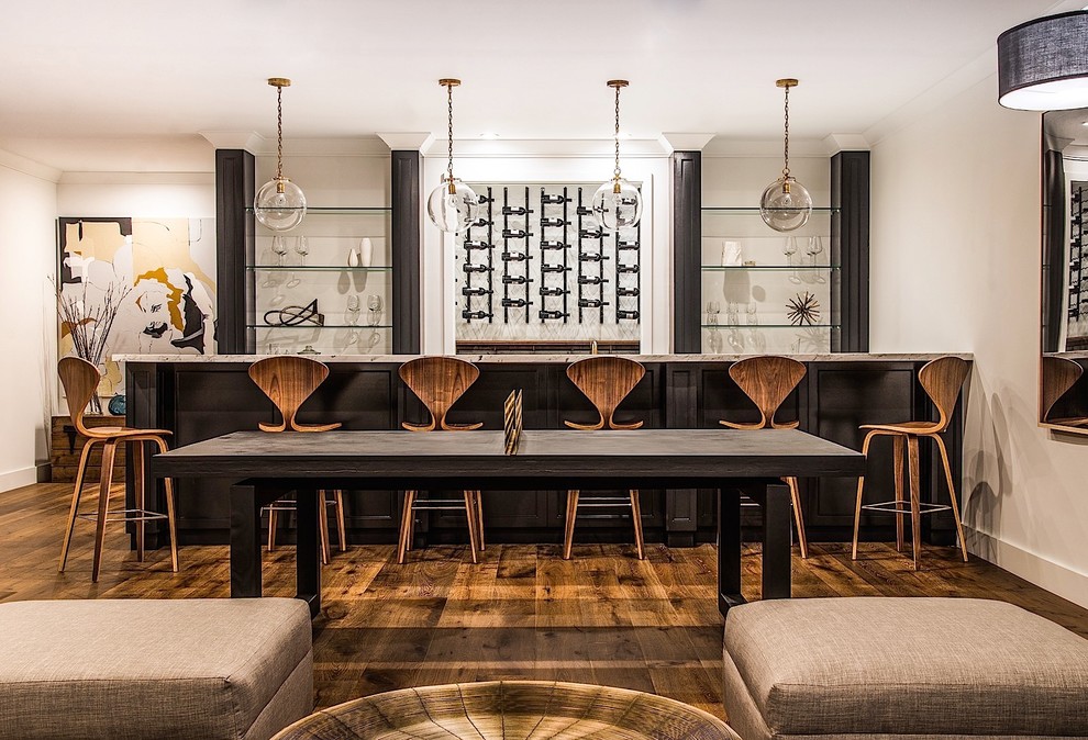 Seated home bar - mid-sized transitional galley medium tone wood floor seated home bar idea in Los Angeles with black cabinets and white backsplash