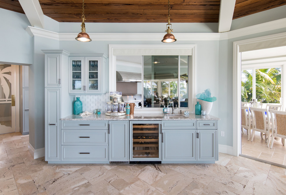 Inspiration for a coastal single-wall beige floor wet bar remodel in Miami with an undermount sink, recessed-panel cabinets, blue cabinets, multicolored backsplash and gray countertops
