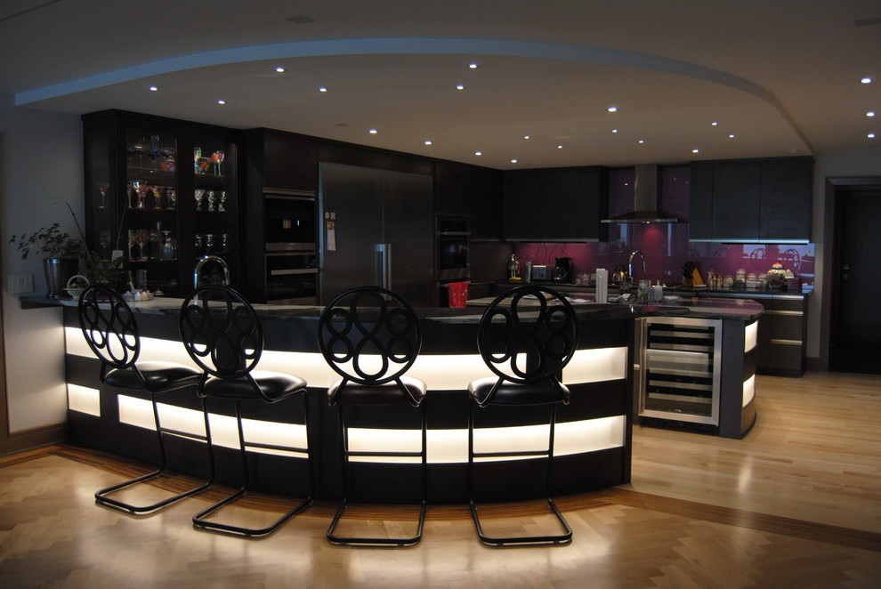 Inspiration for a large contemporary u-shaped breakfast bar in Cleveland with a built-in sink, flat-panel cabinets, black cabinets, composite countertops, red splashback, metro tiled splashback and light hardwood flooring.