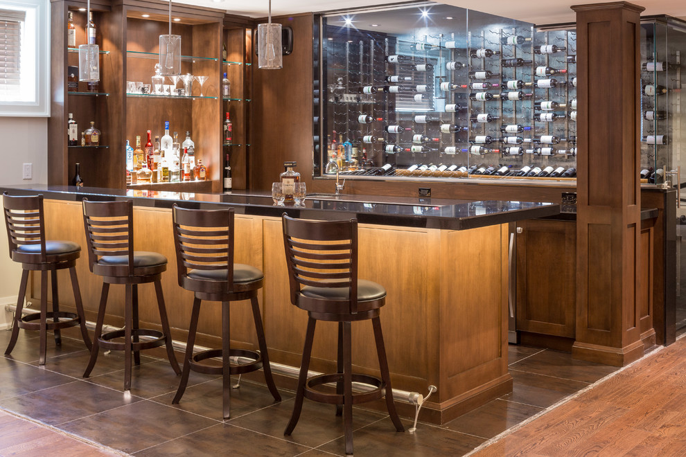 Cette photo montre un bar de salon chic en U et bois foncé avec des tabourets, un placard à porte shaker et un sol marron.