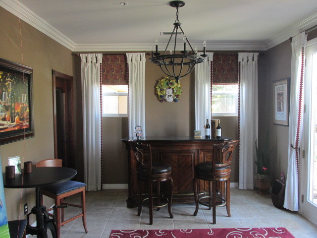 Foto på en liten medelhavsstil hemmabar med stolar, med luckor med upphöjd panel, skåp i mörkt trä, granitbänkskiva och klinkergolv i porslin
