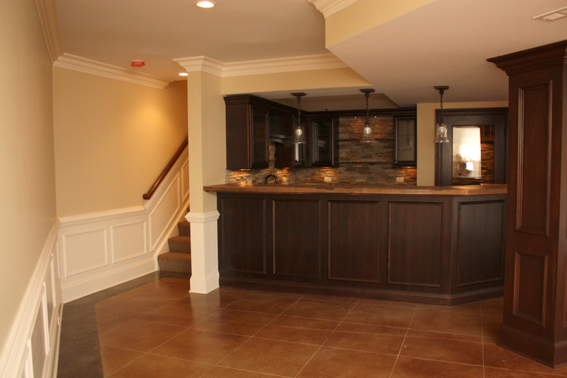Large traditional home bar in Chicago with ceramic flooring.