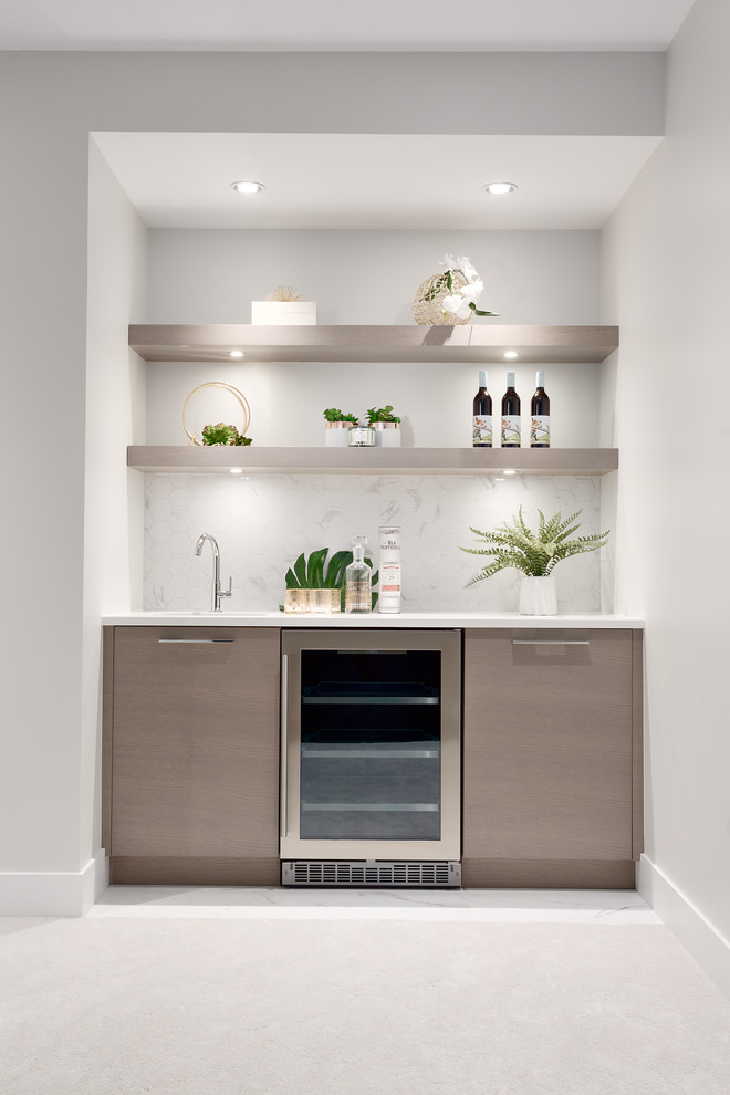 This is an example of a medium sized contemporary single-wall wet bar in Vancouver with a submerged sink, flat-panel cabinets, light wood cabinets, marble worktops, white splashback, marble splashback, carpet, beige floors and white worktops.