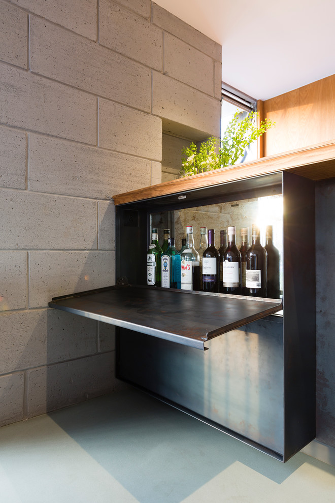 Diseño de bar en casa lineal contemporáneo pequeño con armarios con paneles lisos, puertas de armario negras, encimera de madera, salpicadero negro y suelo de cemento