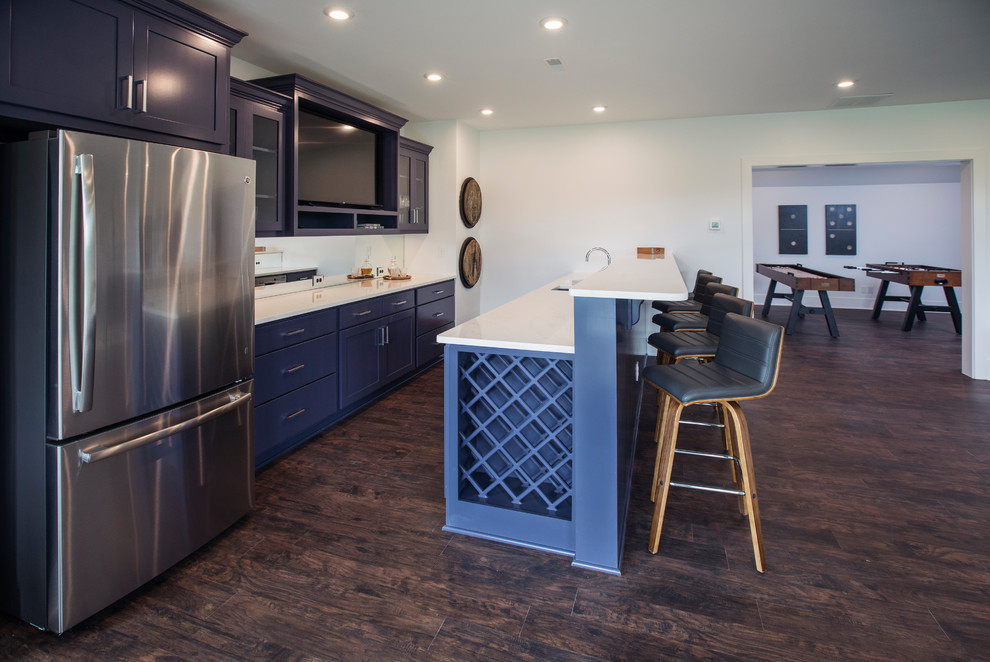 Inspiration for a large contemporary galley dark wood floor and brown floor seated home bar remodel in Louisville with an undermount sink, recessed-panel cabinets, blue cabinets, quartz countertops, mirror backsplash and white countertops