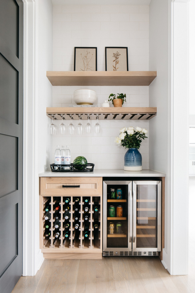 Inspiration for a transitional single-wall light wood floor and beige floor dry bar remodel in Chicago with no sink, shaker cabinets, light wood cabinets, marble countertops, white backsplash, subway tile backsplash and white countertops