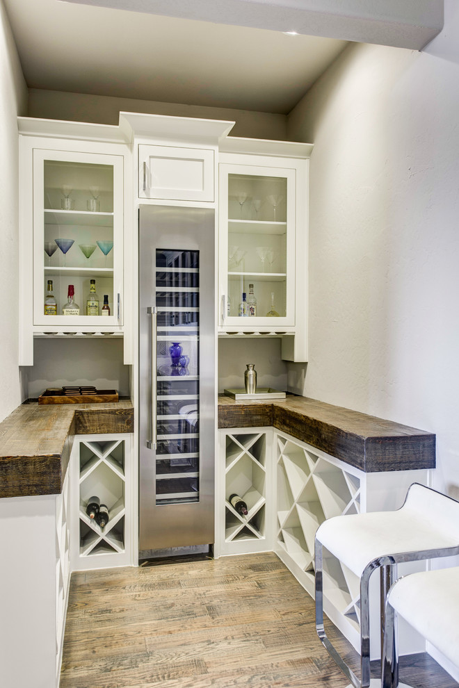 Inspiration for a mid-sized transitional u-shaped dark wood floor and brown floor wet bar remodel in Dallas with an undermount sink, glass-front cabinets, white cabinets, granite countertops, white backsplash and subway tile backsplash