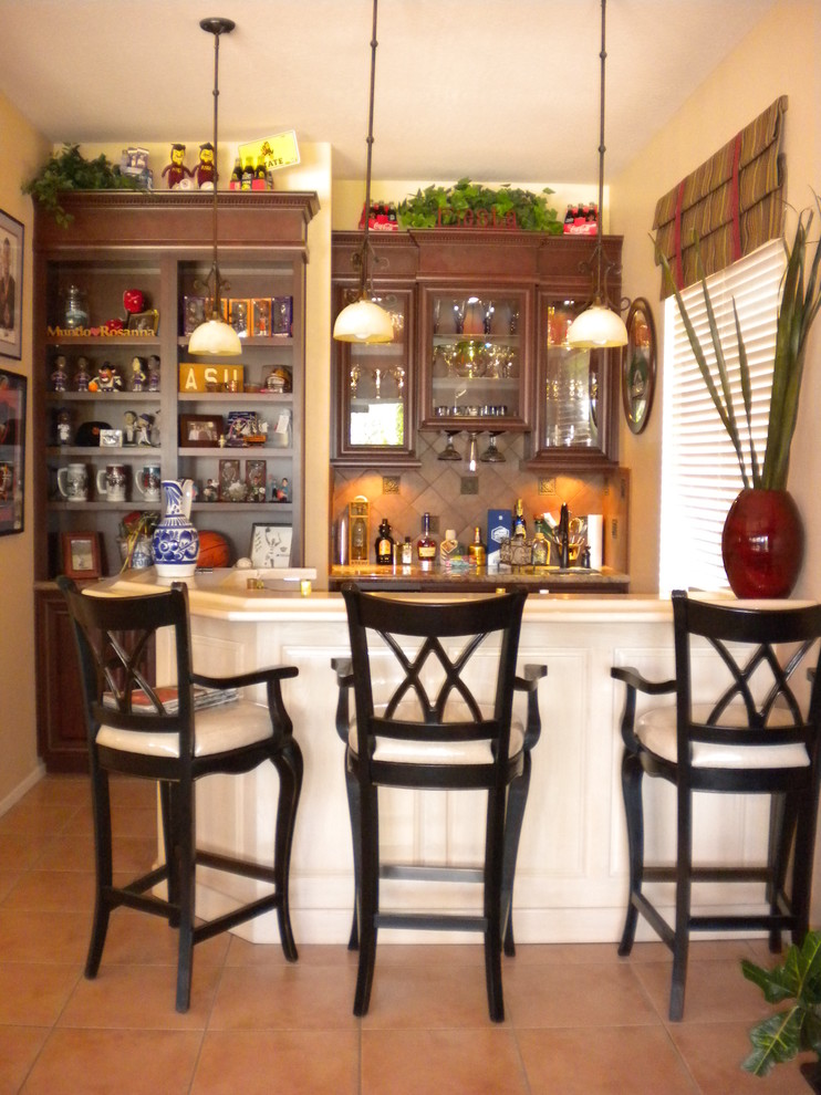 Seated home bar - small traditional single-wall terra-cotta tile and beige floor seated home bar idea in Phoenix with raised-panel cabinets, dark wood cabinets, quartzite countertops, brown backsplash, terra-cotta backsplash and beige countertops