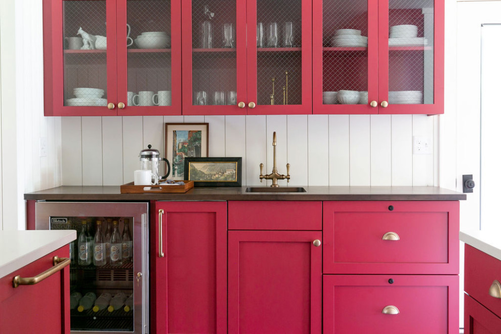 Small coastal galley home bar in New York with a submerged sink, shaker cabinets, red cabinets, wood worktops, white splashback, wood splashback, vinyl flooring, brown floors and brown worktops.