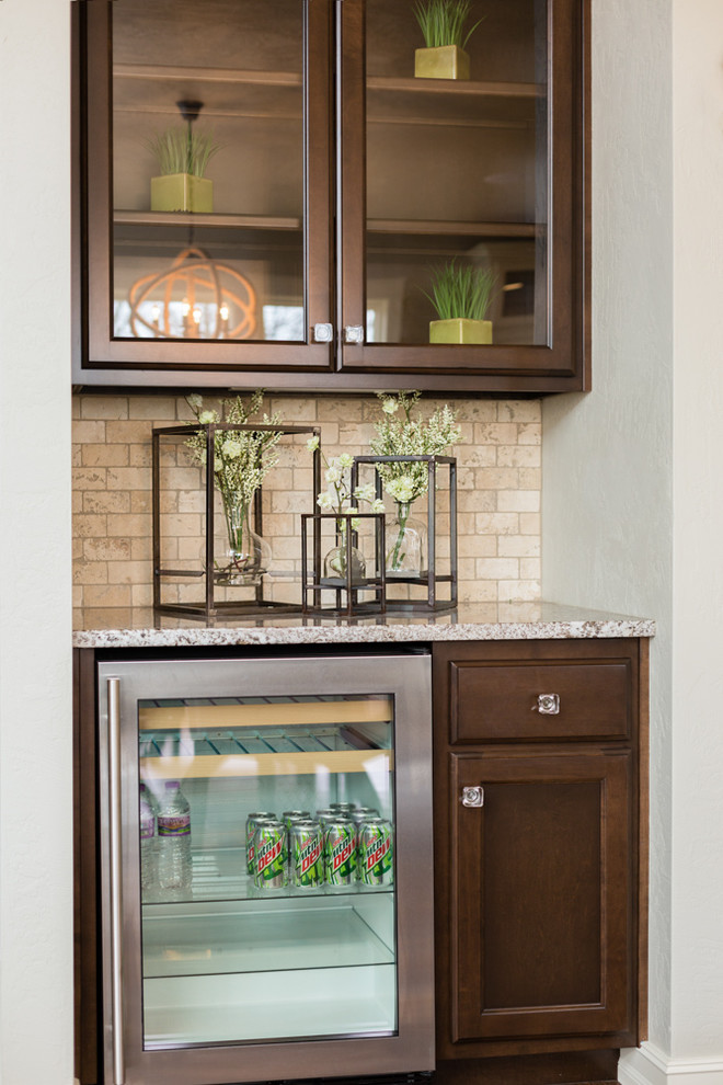 Inspiration for a small craftsman single-wall wet bar remodel in Other with glass-front cabinets, dark wood cabinets, quartzite countertops, beige backsplash and stone tile backsplash